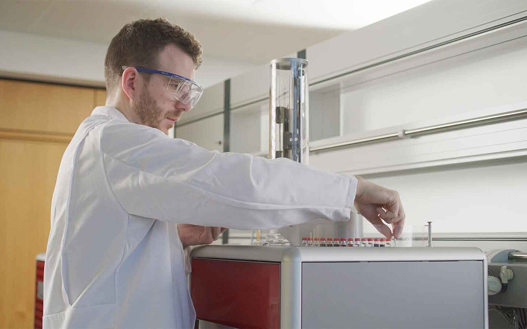 Male lab employee is placing samples on an oxygen analyzer