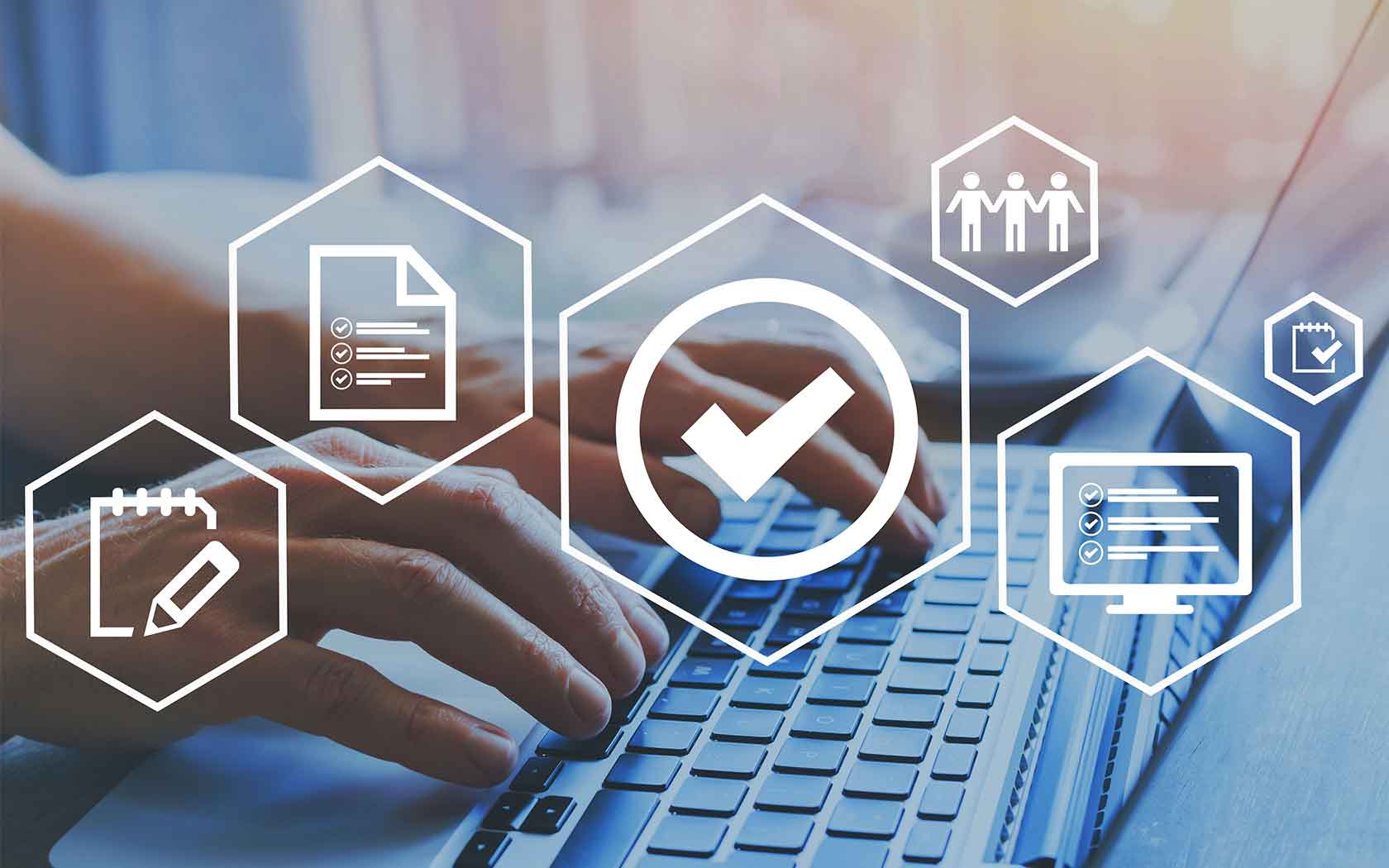 Hands on computer keys with an overlay of quality control icons
